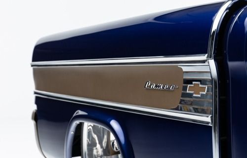 Close-up of a blue vintage Chevrolet pickup truck with chrome trim and emblem