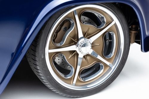 Close-up of a bronze custom car wheel with a low-profile tire on a blue vehicle