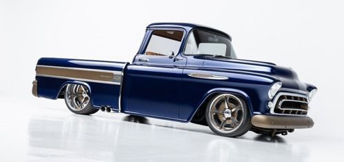 Blue classic lowrider pickup truck on a white background, shown in side view with chrome details