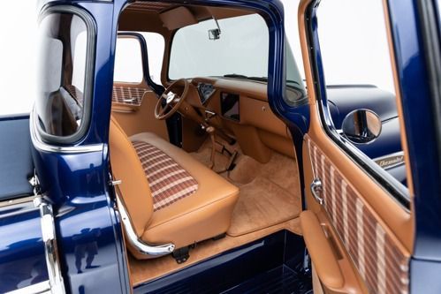 Open car door revealing a tan leather interior and blue exterior trim
