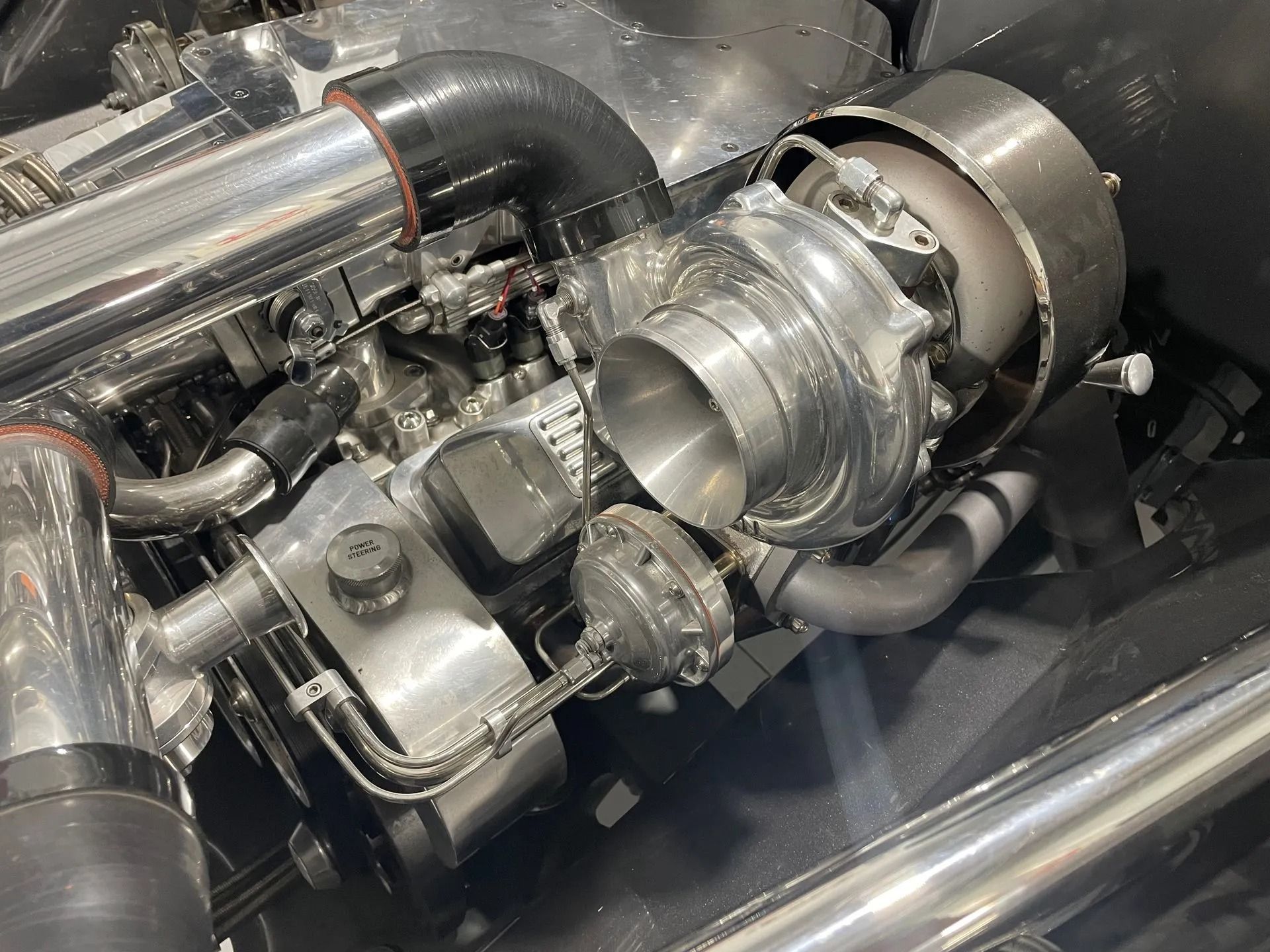 Shiny turbocharger and engine components with polished metal piping in a mechanical setup