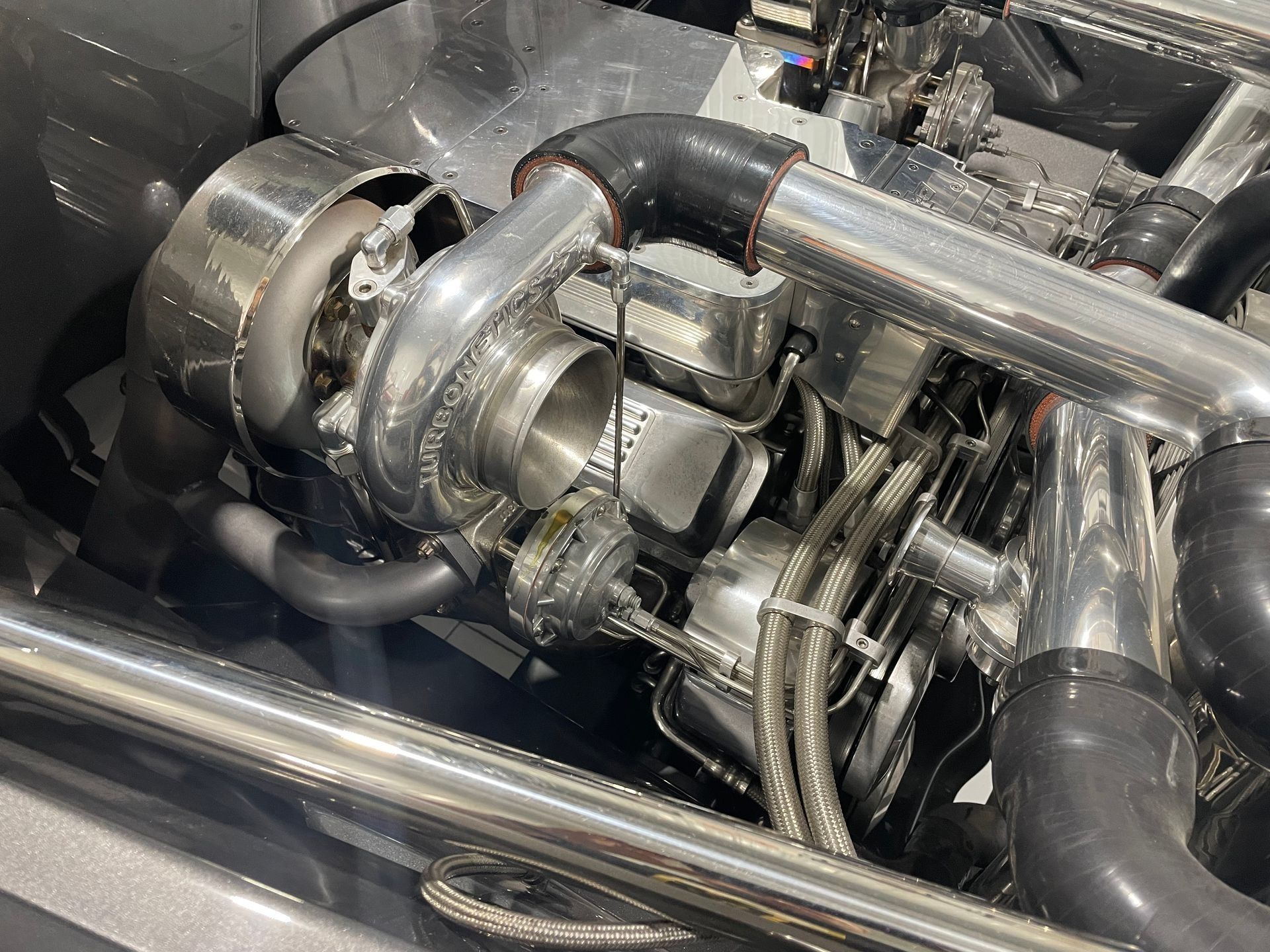 Close-up of a turbocharger and polished engine piping in a car engine bay