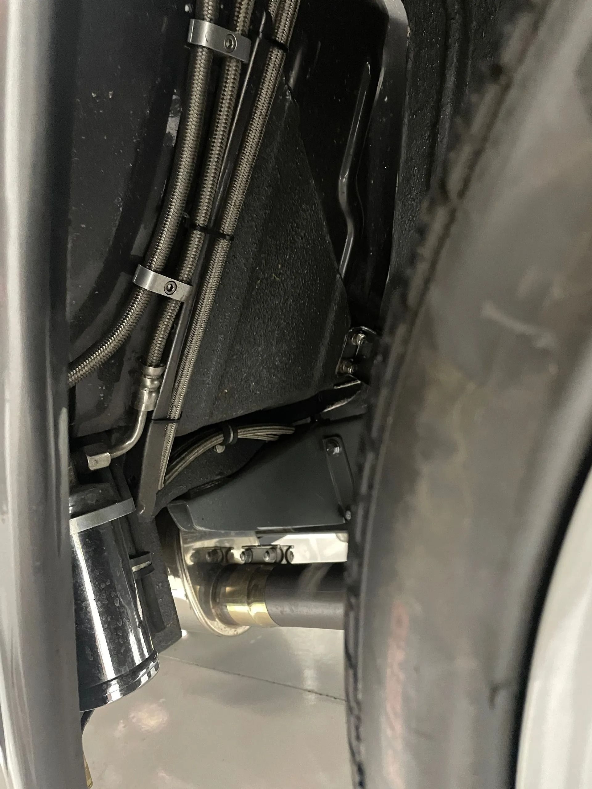 Close-up of wiring and a metal connector inside a dark mechanical compartment