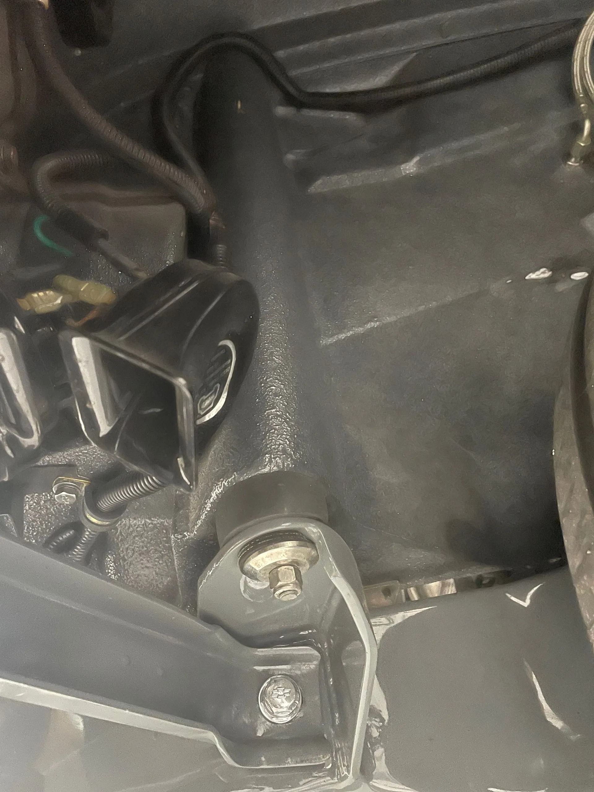Close-up of a black plastic car interior panel with a visible screw and wiring clip.
