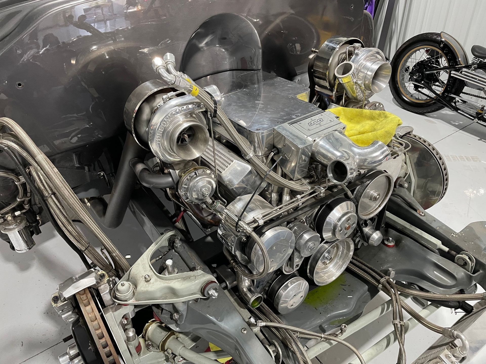 Mechanical engine assembly with silver turbochargers and exposed pipes on a workbench