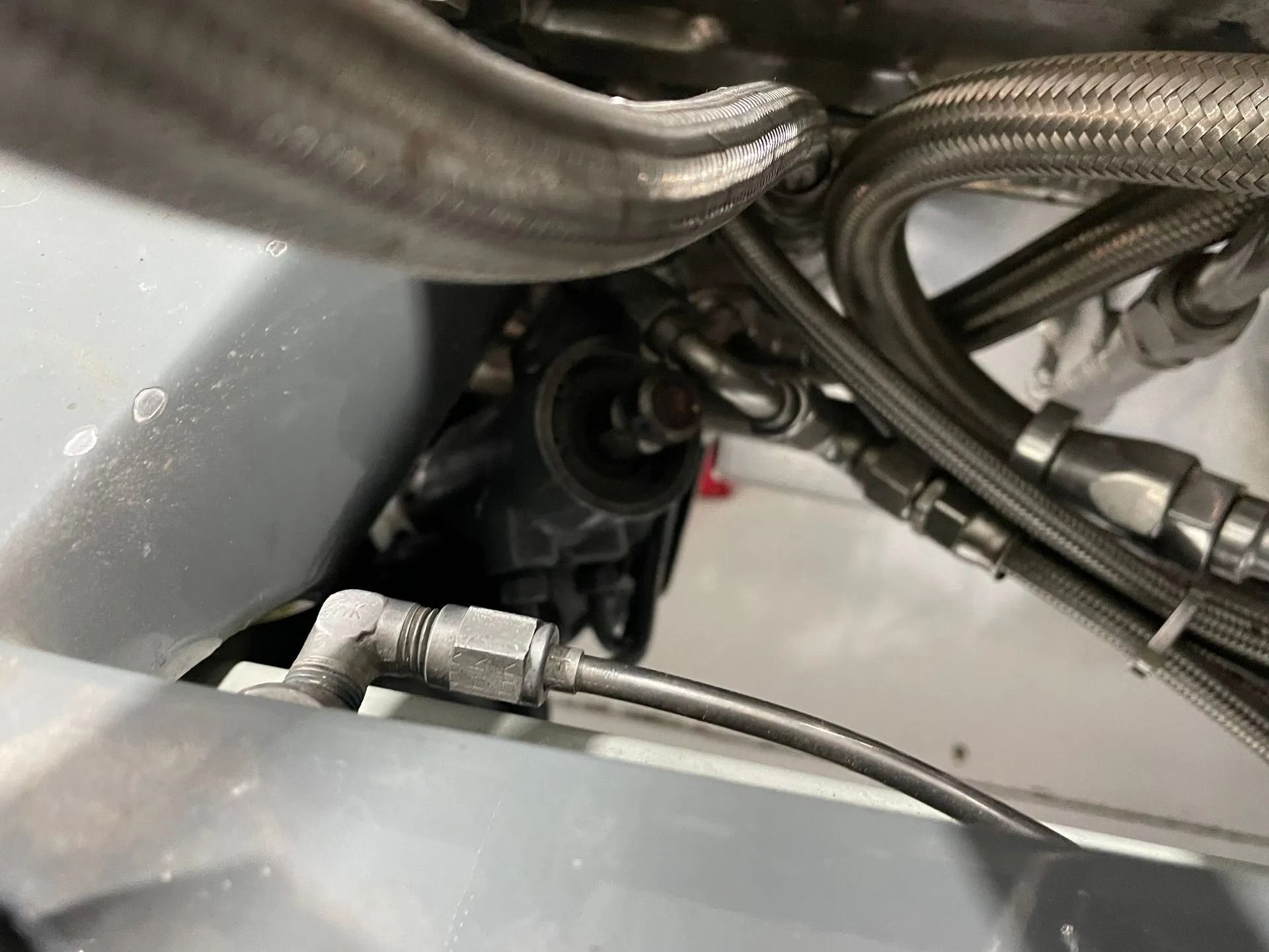 Close-up of metal hoses and hydraulic fittings inside a machine compartment