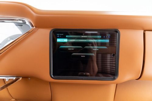Black touchscreen display set into a tan car dashboard interior