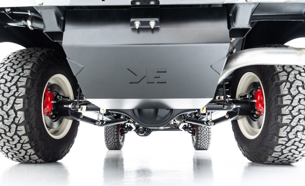 Undercarriage of a lifted off-road vehicle with large knobby tires and suspension components visible