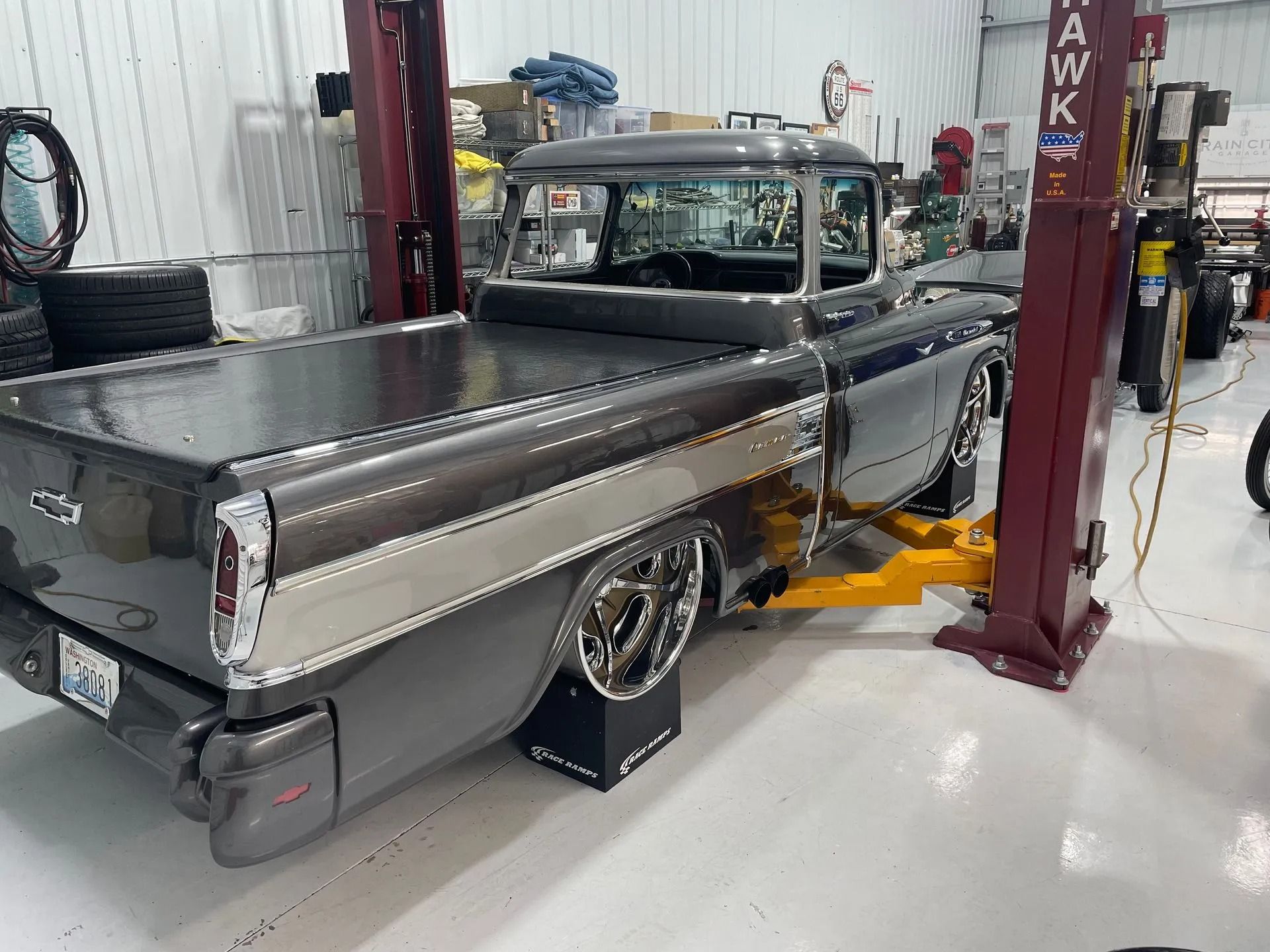 Classic black pickup truck on a lift in an auto shop garage
