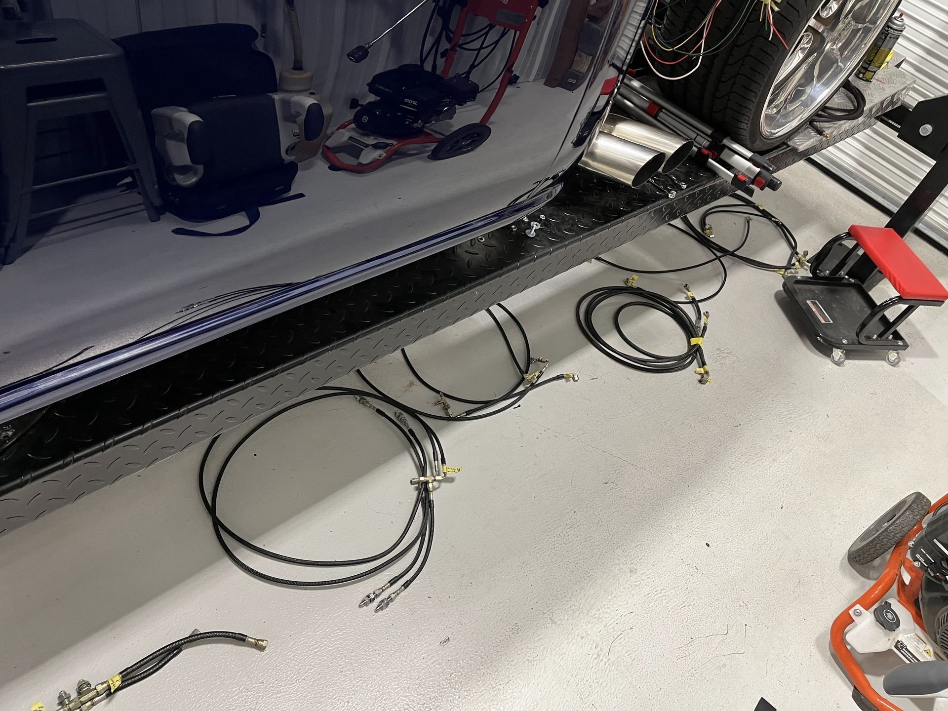Coiled cables on a light floor beside industrial machinery and tools in a workshop or lab area