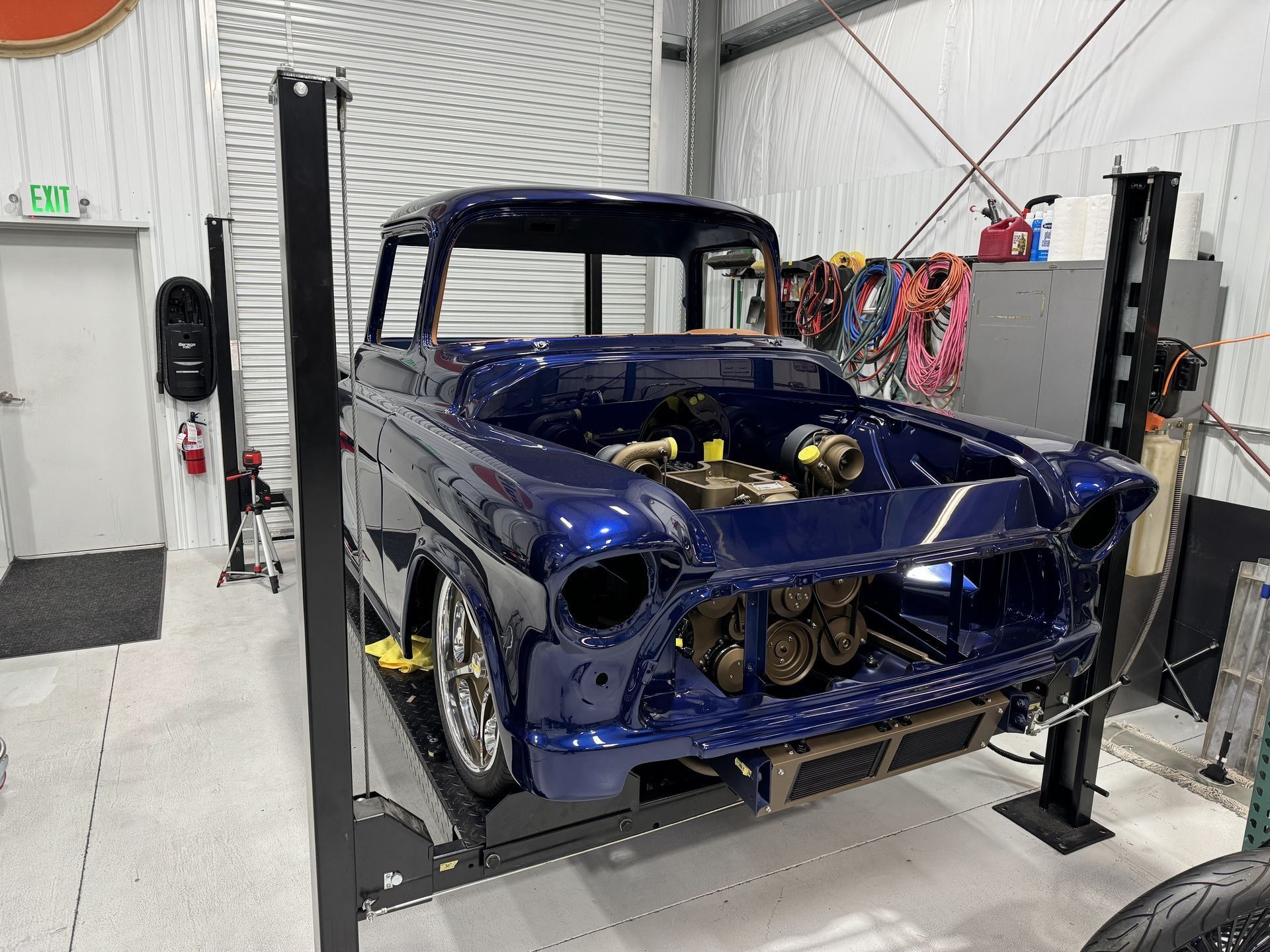Blue classic truck on a vehicle lift in a garage workshop