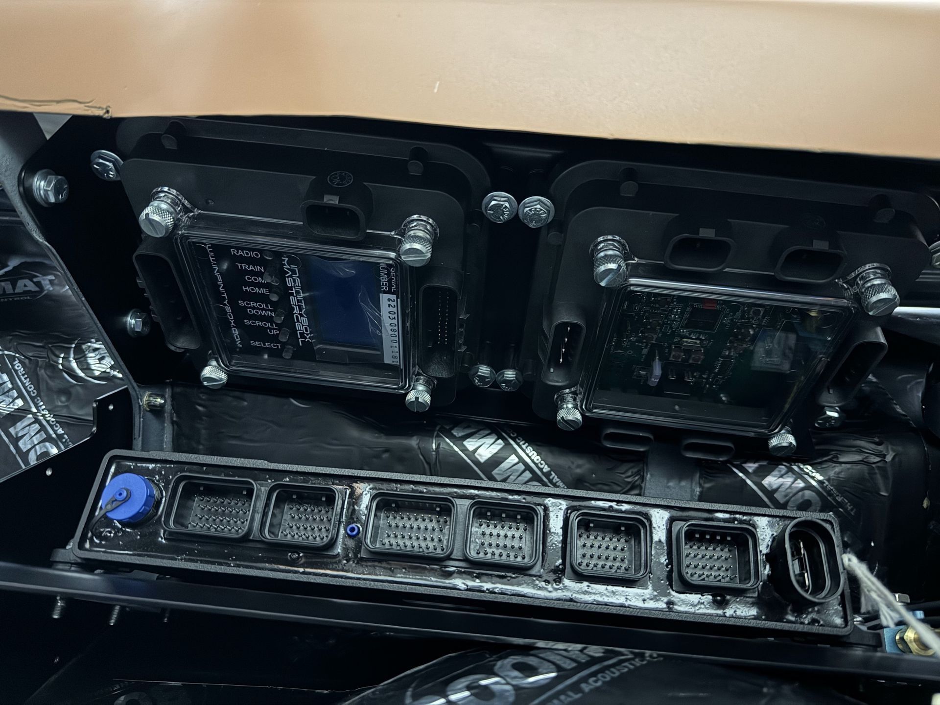 Open electronics case with circuit boards and ports, plus a row of connectors at the bottom.