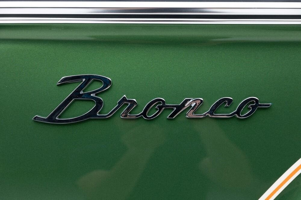 Black “Bronco” emblem on a green vehicle body panel