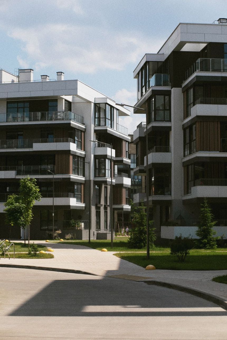 Modern apartment buildings with balconies lining a landscaped courtyard pathway