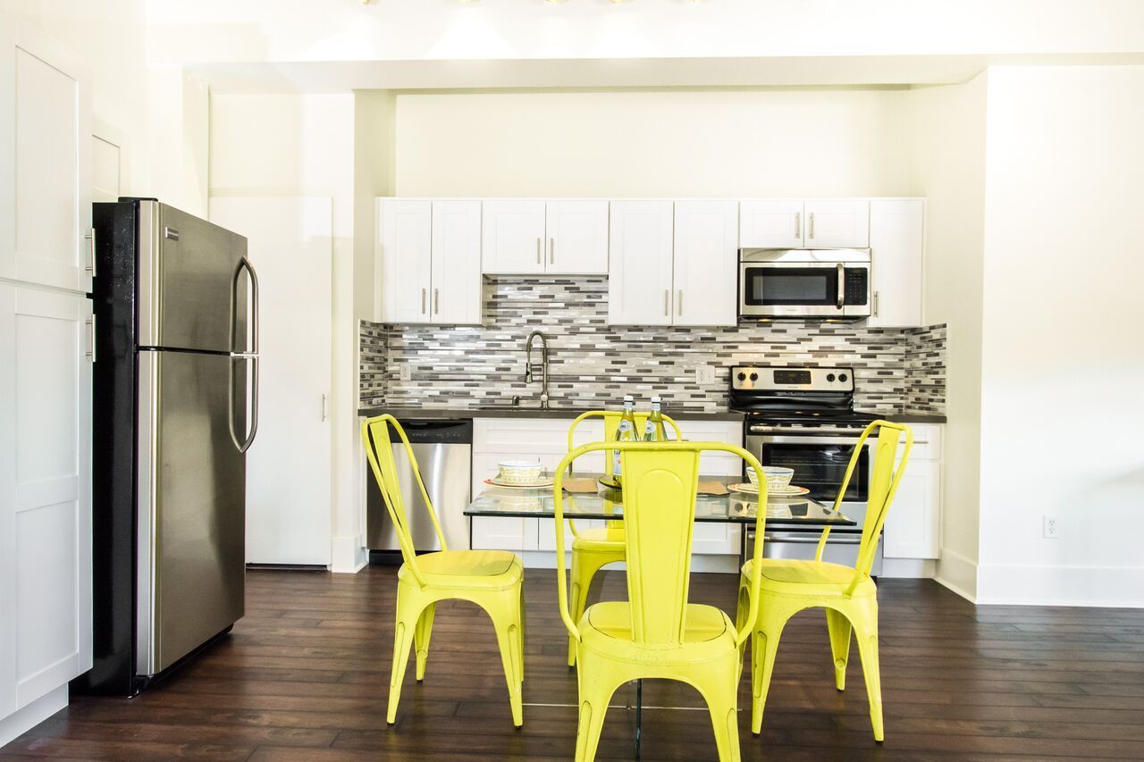 A kitchen with a table and chairs and a refrigerator.