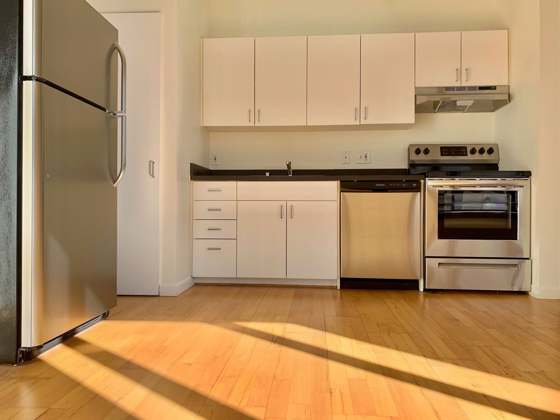 A kitchen with stainless steel appliances and white cabinets