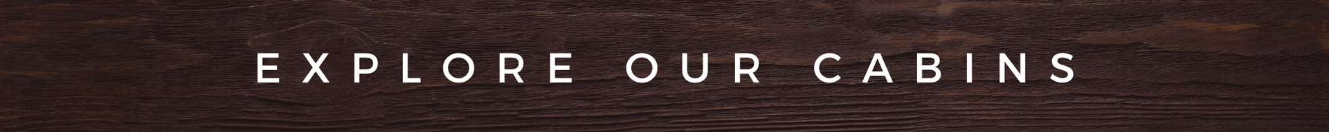 “Explore our cabins” banner on a rustic wood background