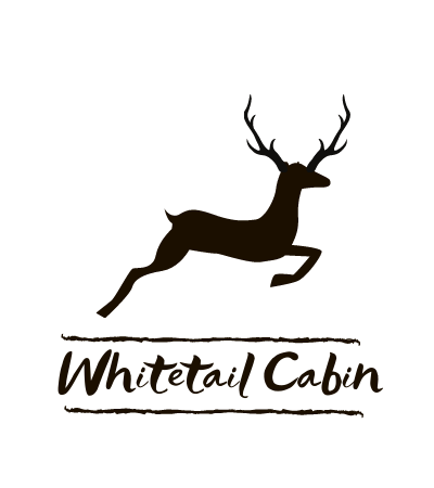Whitetail Cabin logo with a leaping deer silhouette and antlers on a white background