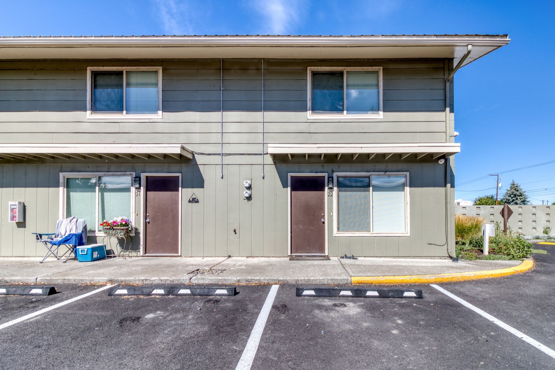 A large apartment building with a parking lot in front of it.