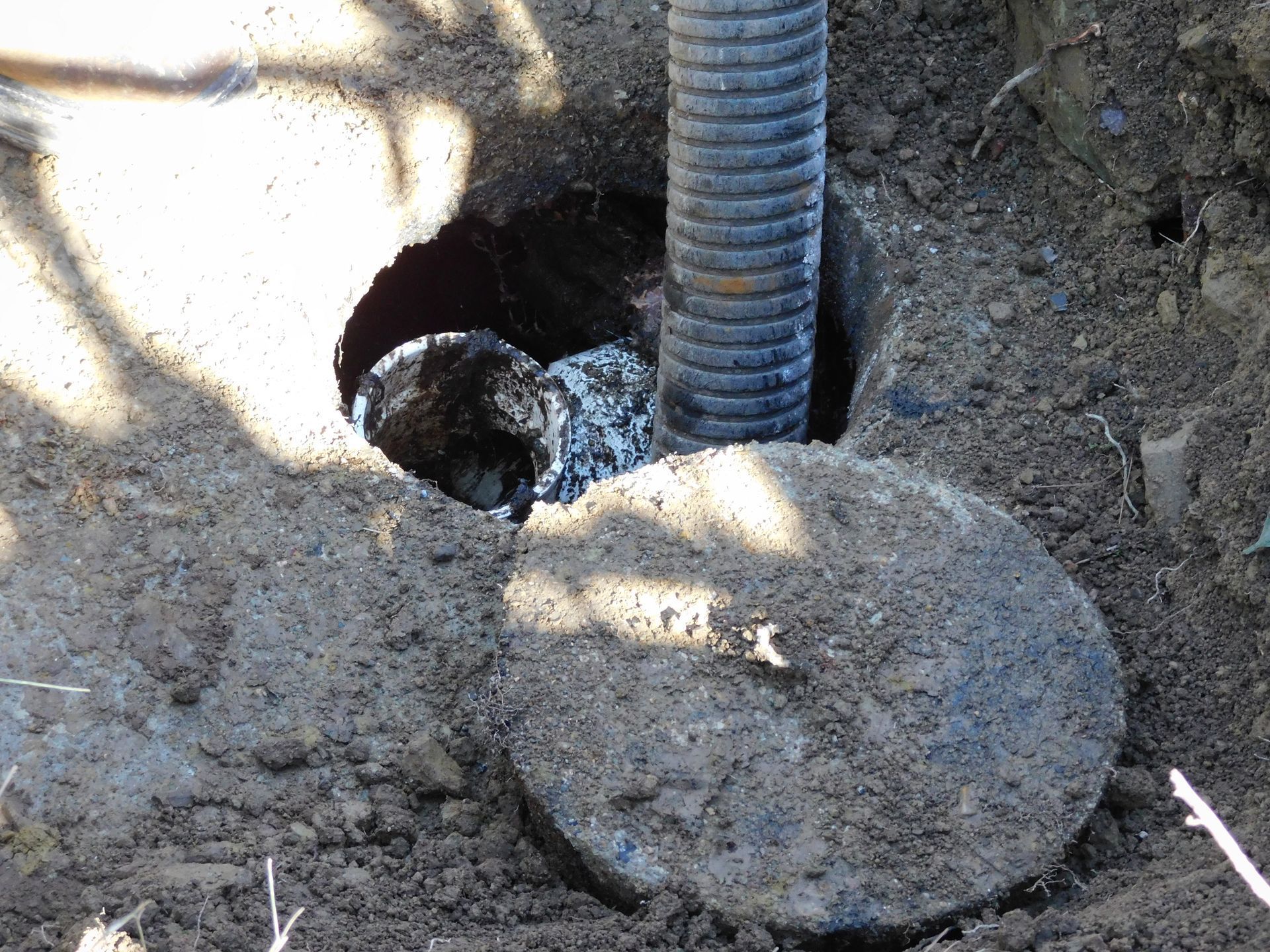 A hose is coming out of a hole in the ground.