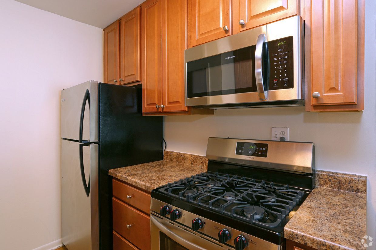 Small kitchen with stainless steel appliances, wood cabinets, and granite countertops