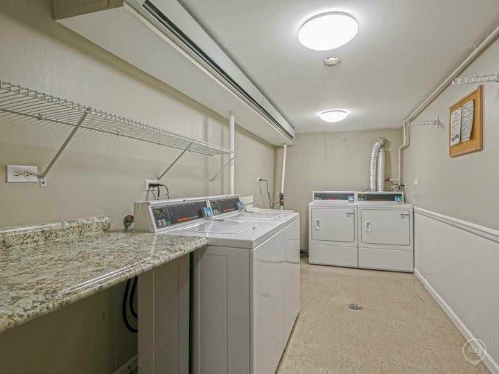 Laundry room with washer, dryer, utility sink, shelving, and a granite countertop