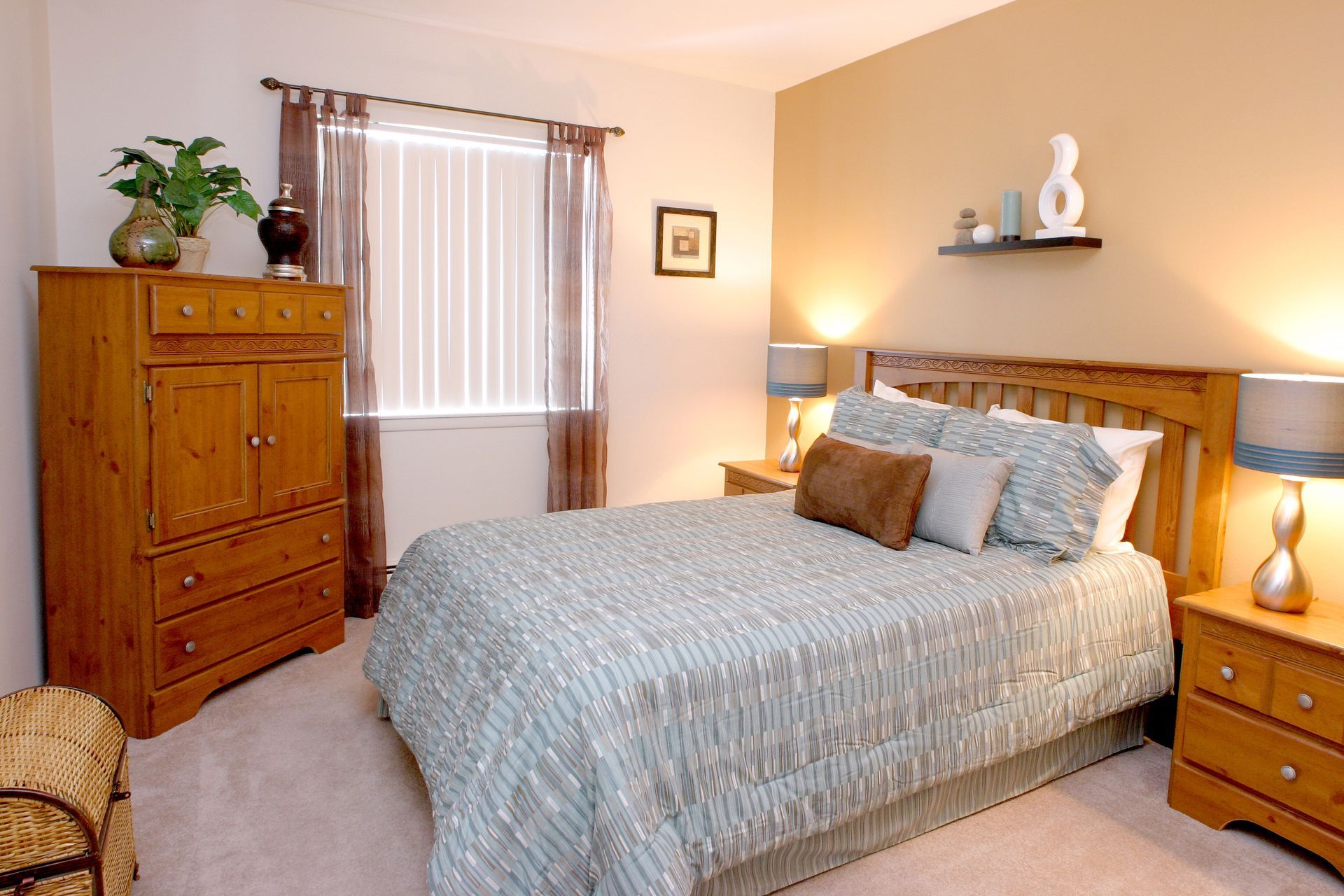 Bedroom with a bed, wooden dresser, nightstands, and a window with curtains.