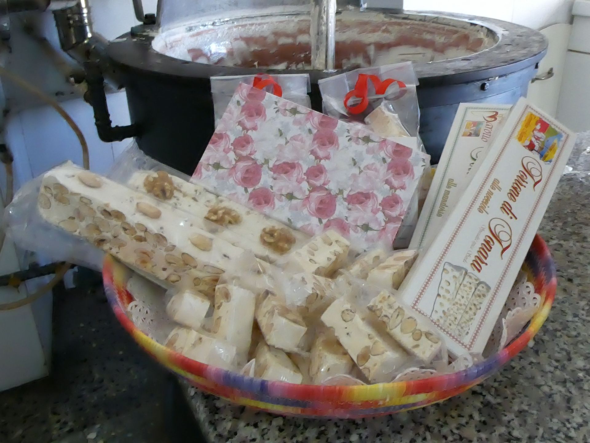 Cestino di torrone, con noci a vista, davanti a una grande pentola.