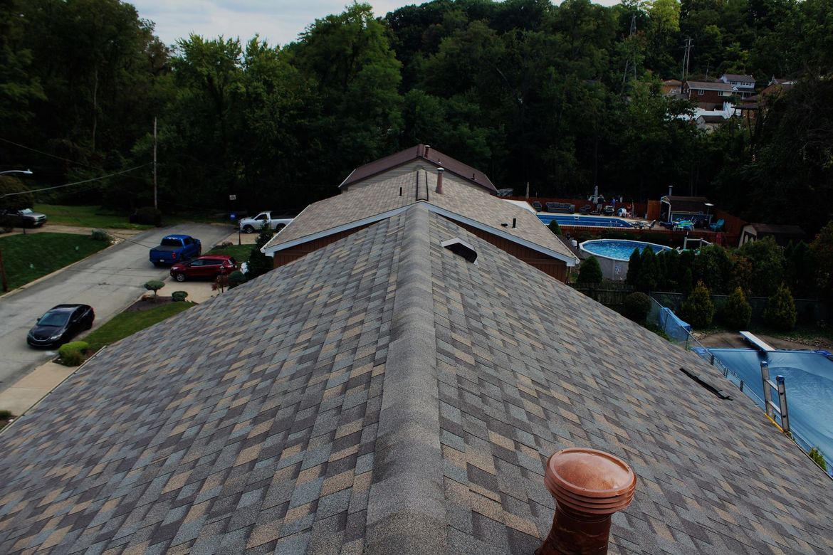 Roof from the ridge with brown shingles and brown vents