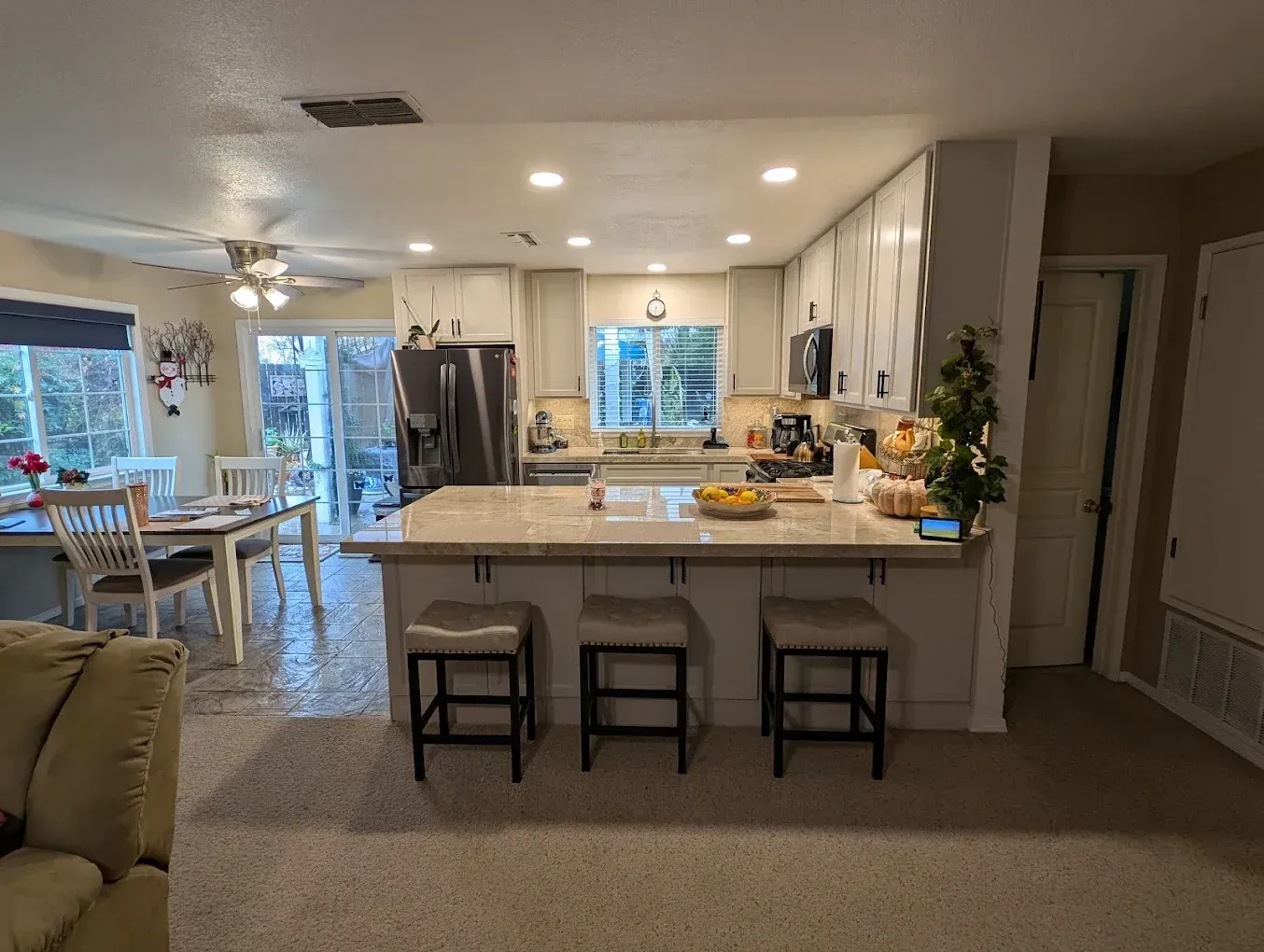 Kitchen with an island, cabinets, appliances, and a dining area.