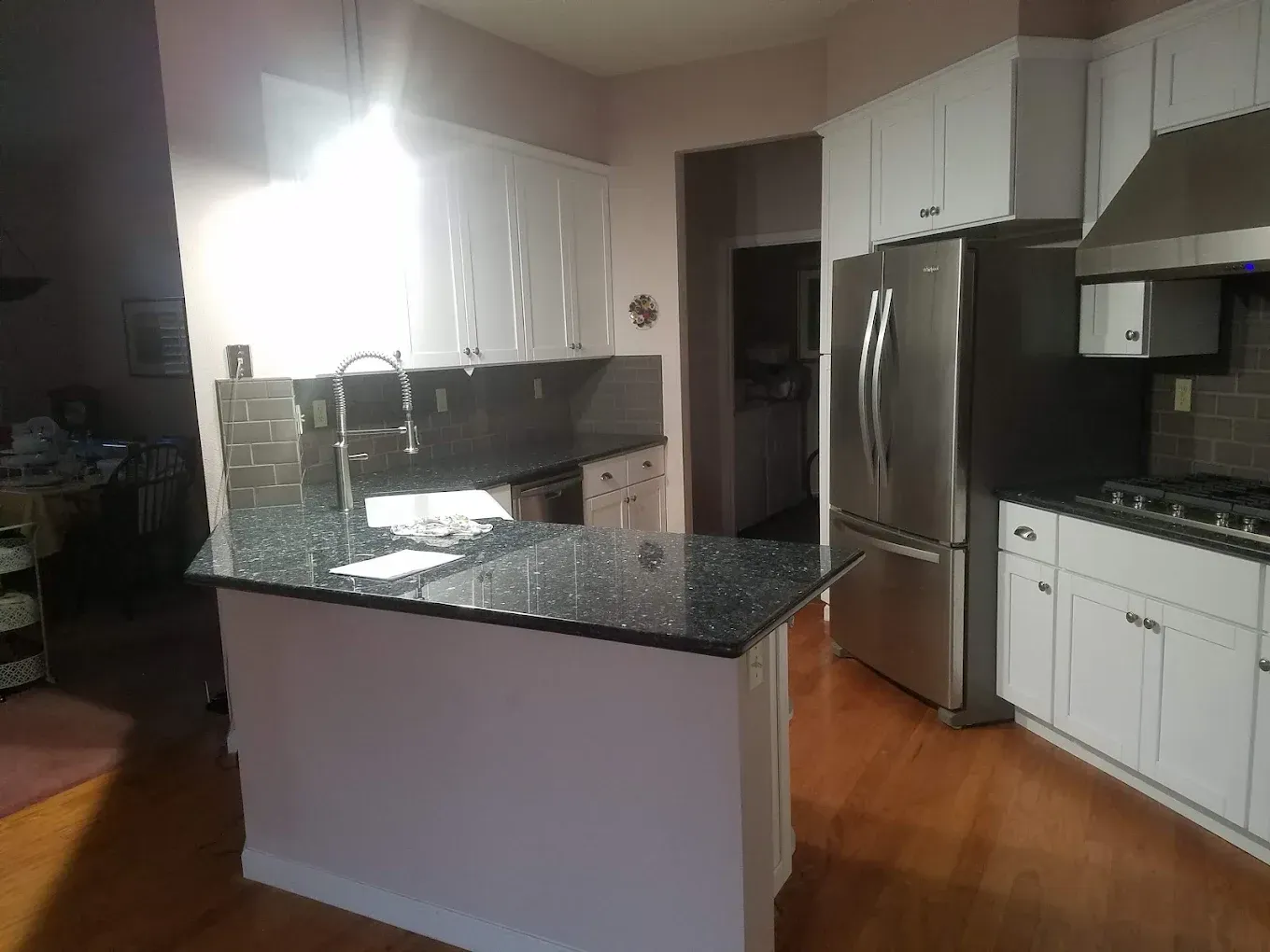 Kitchen with white cabinets, stainless steel appliances, and dark countertops.