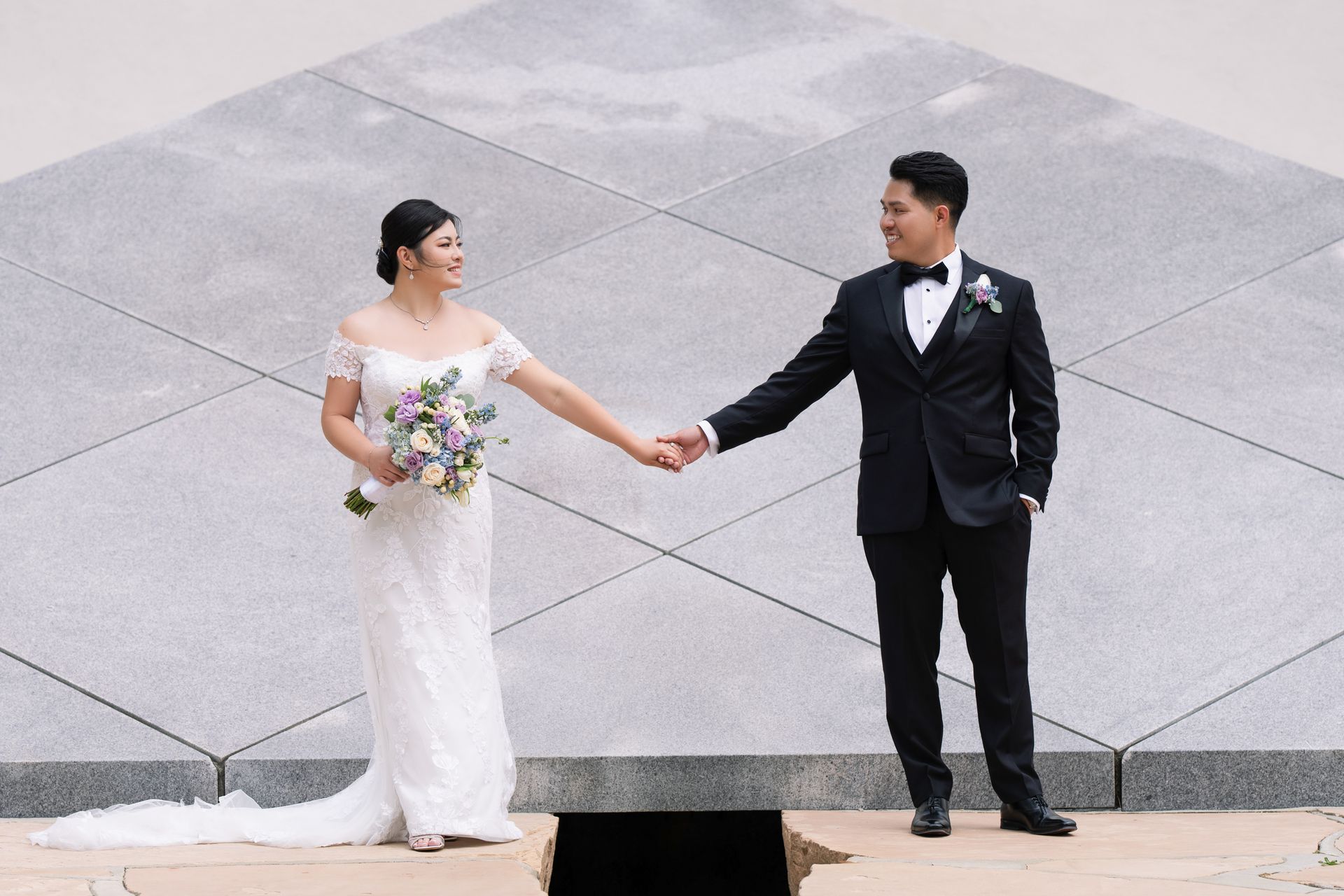 Bride and groom holding hands during modern outdoor wedding portrait session