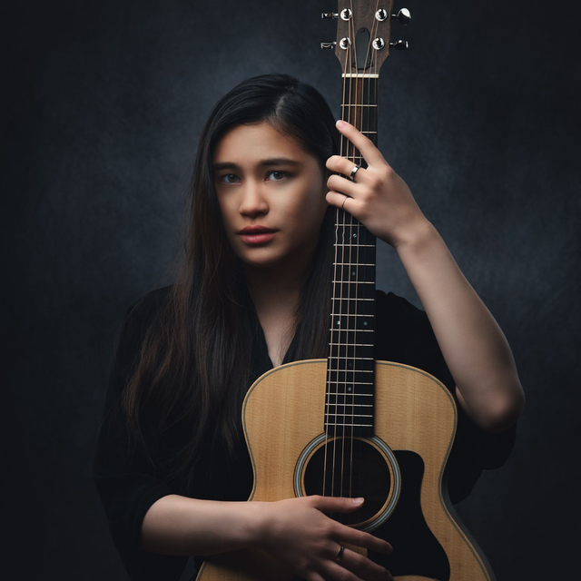 Fine Art portrait of a singer and songwriter holding a guitar.