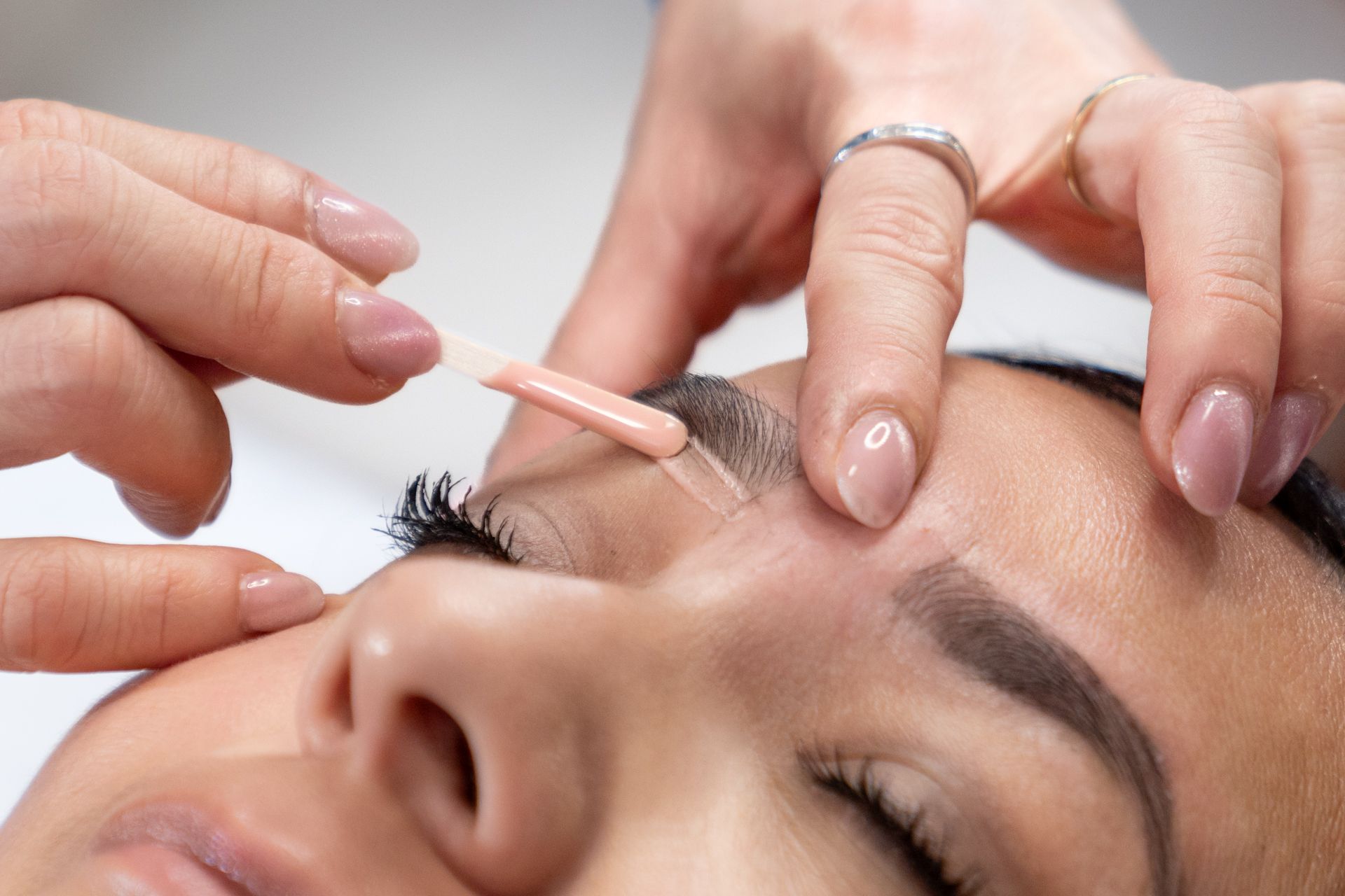 Close-up of professional eyebrow grooming and beauty treatment session
