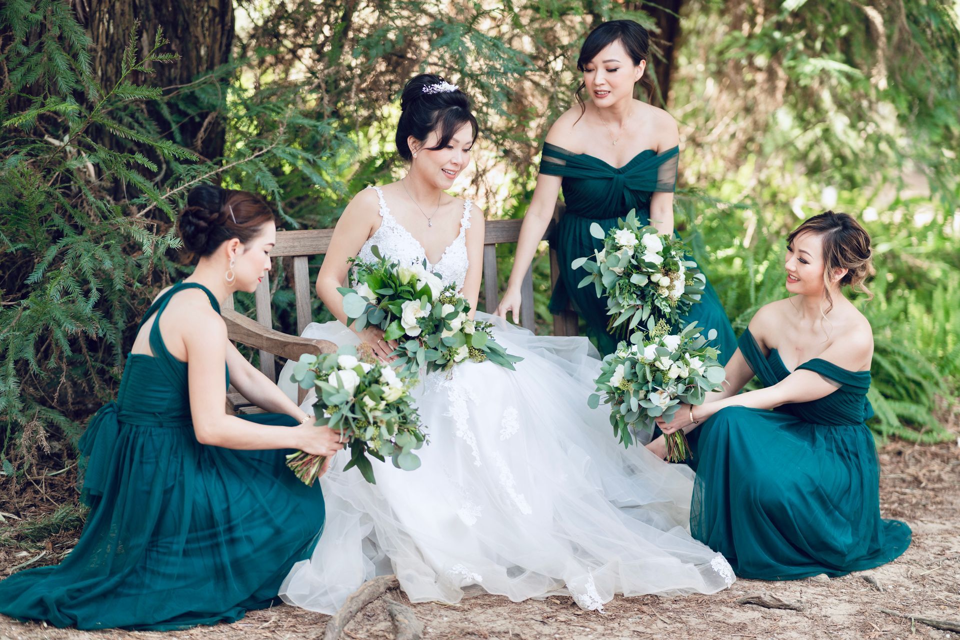 A photo of a bride surrounded by her bride maids in outdoor.