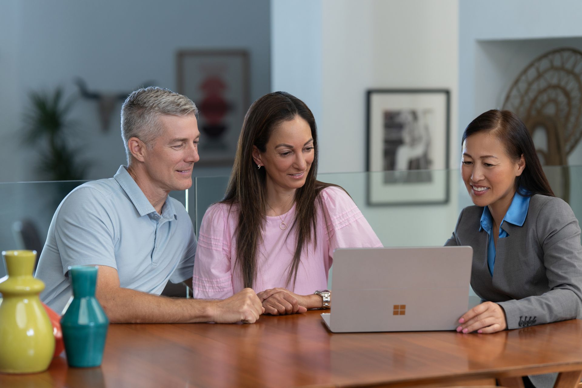 Professional business consultation meeting with clients reviewing information on laptop
