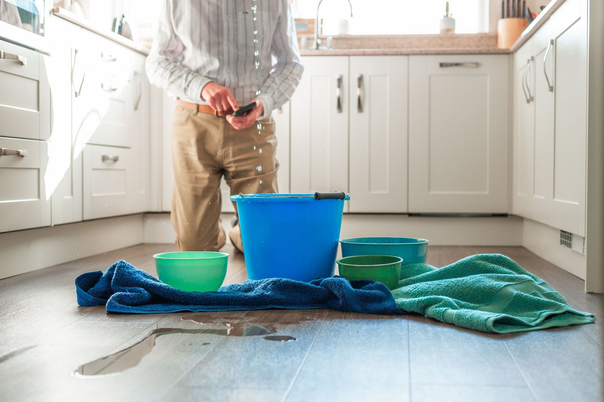 Worried home owner dealing with water leak in the kitchen