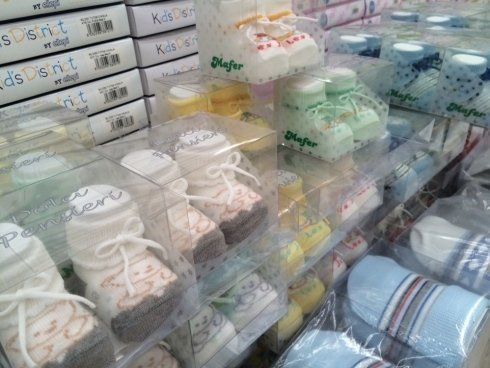 Calzini per neonati in scatole di plastica trasparente sugli scaffali dei negozi.