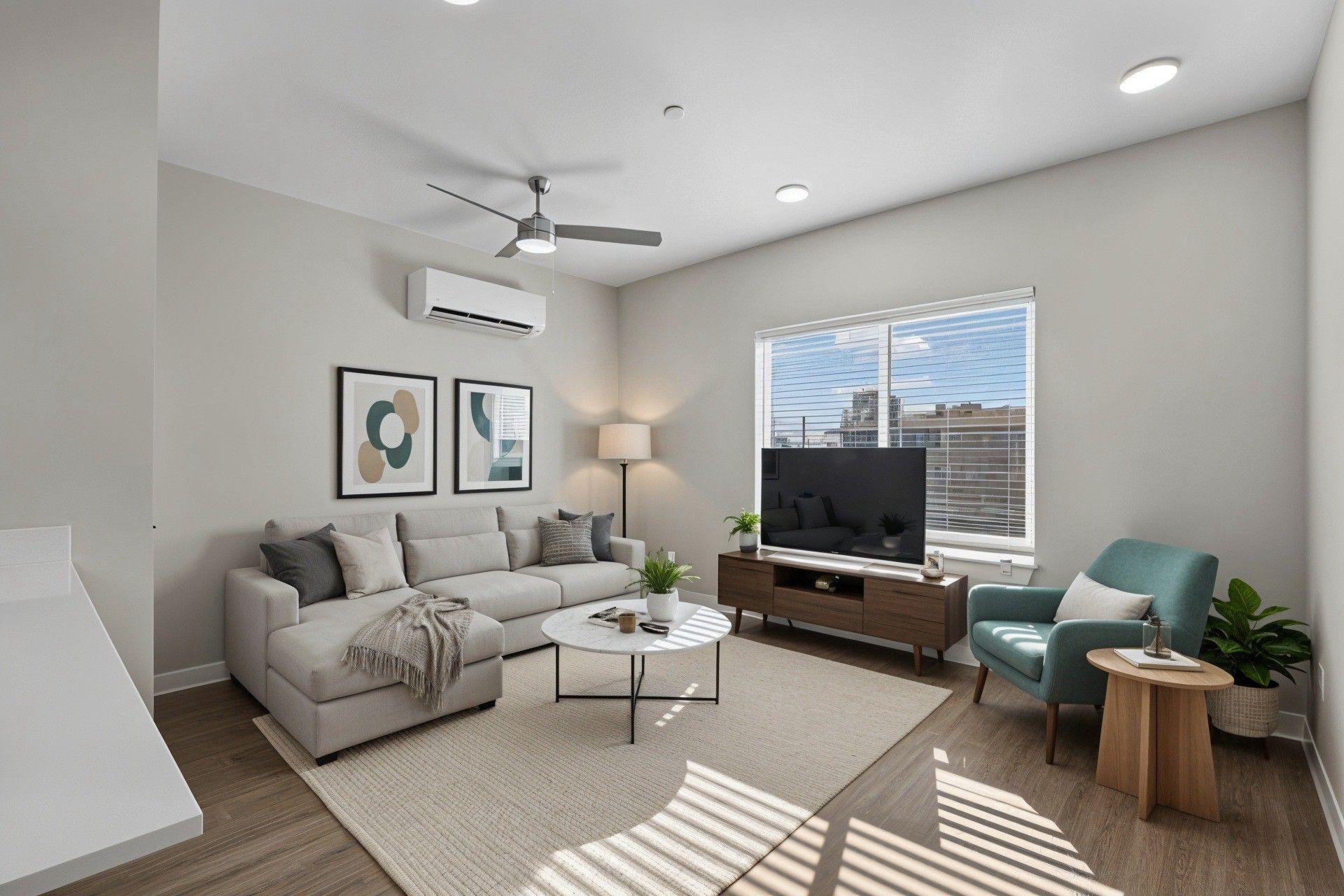Living room with a couch, TV, and armchair. Neutral color scheme, natural light, and a modern design.