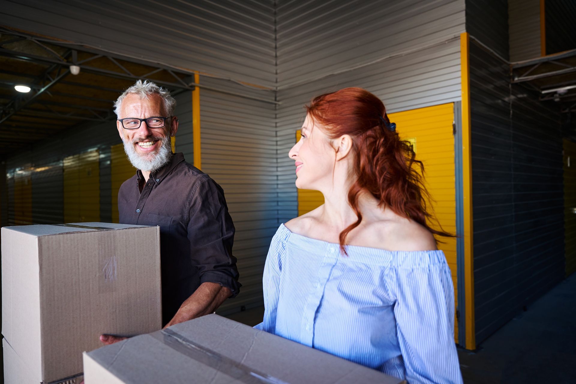 Couple carrying moving boxes inside a self-storage facility in Montgomery, AL.