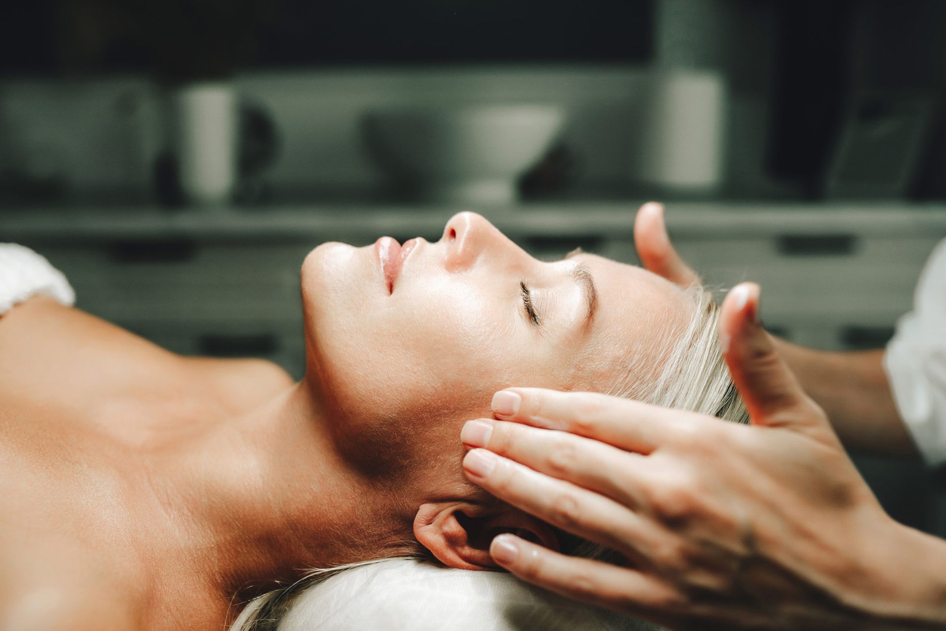 A woman is getting a head massage at a spa.