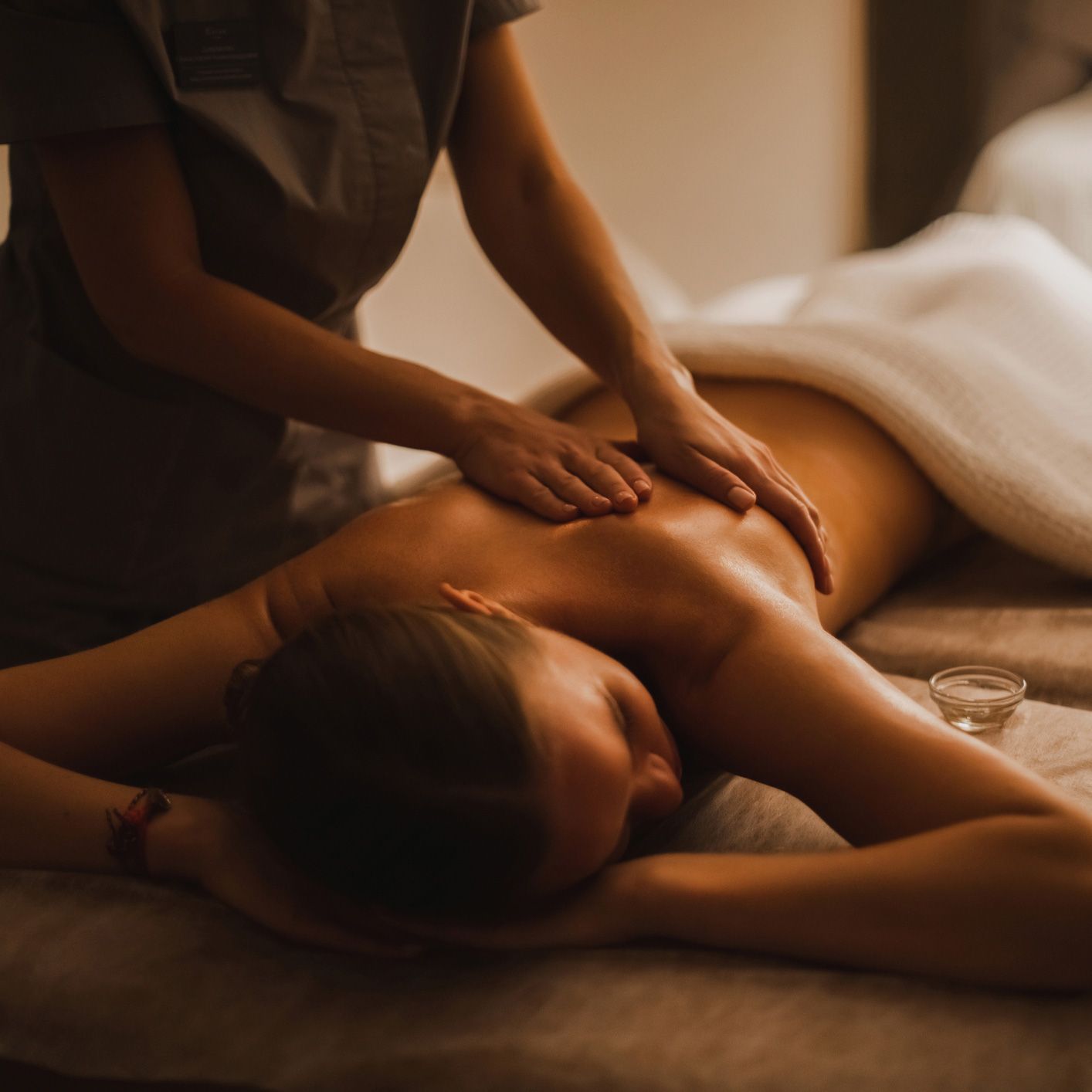 A woman is getting a back massage at a spa.