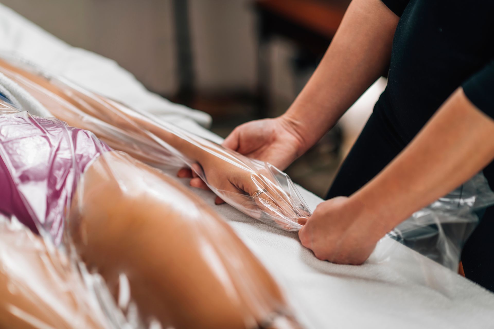 a woman is wrapped in plastic while getting a massage
