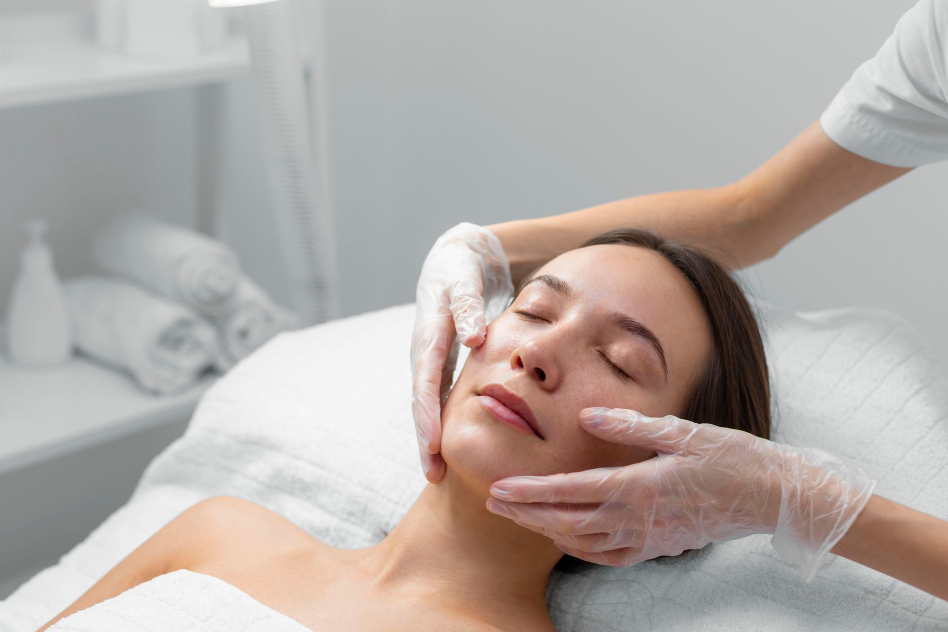 a woman is getting a facial treatment with her eyes closed