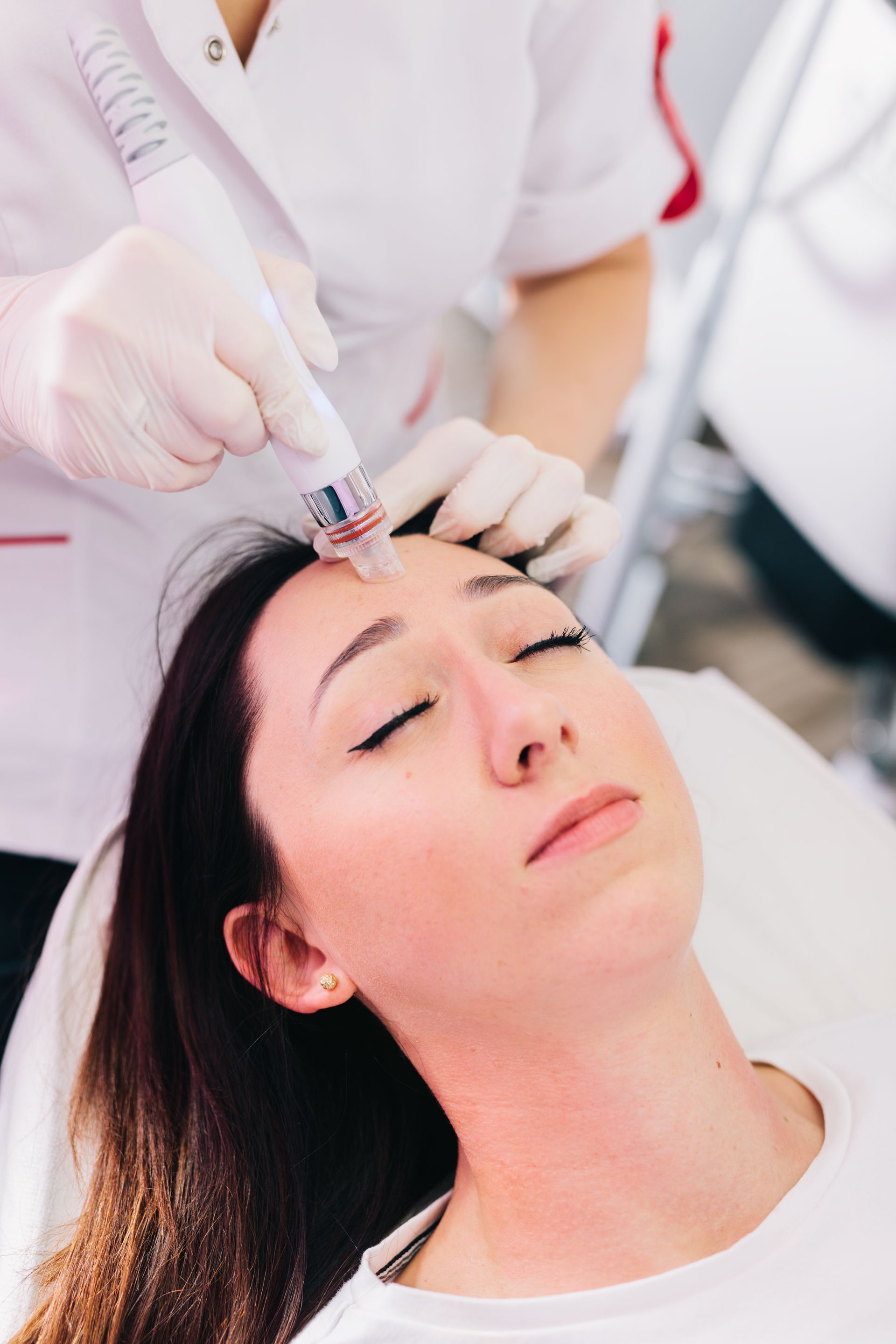 a woman with her eyes closed is getting a facial treatment