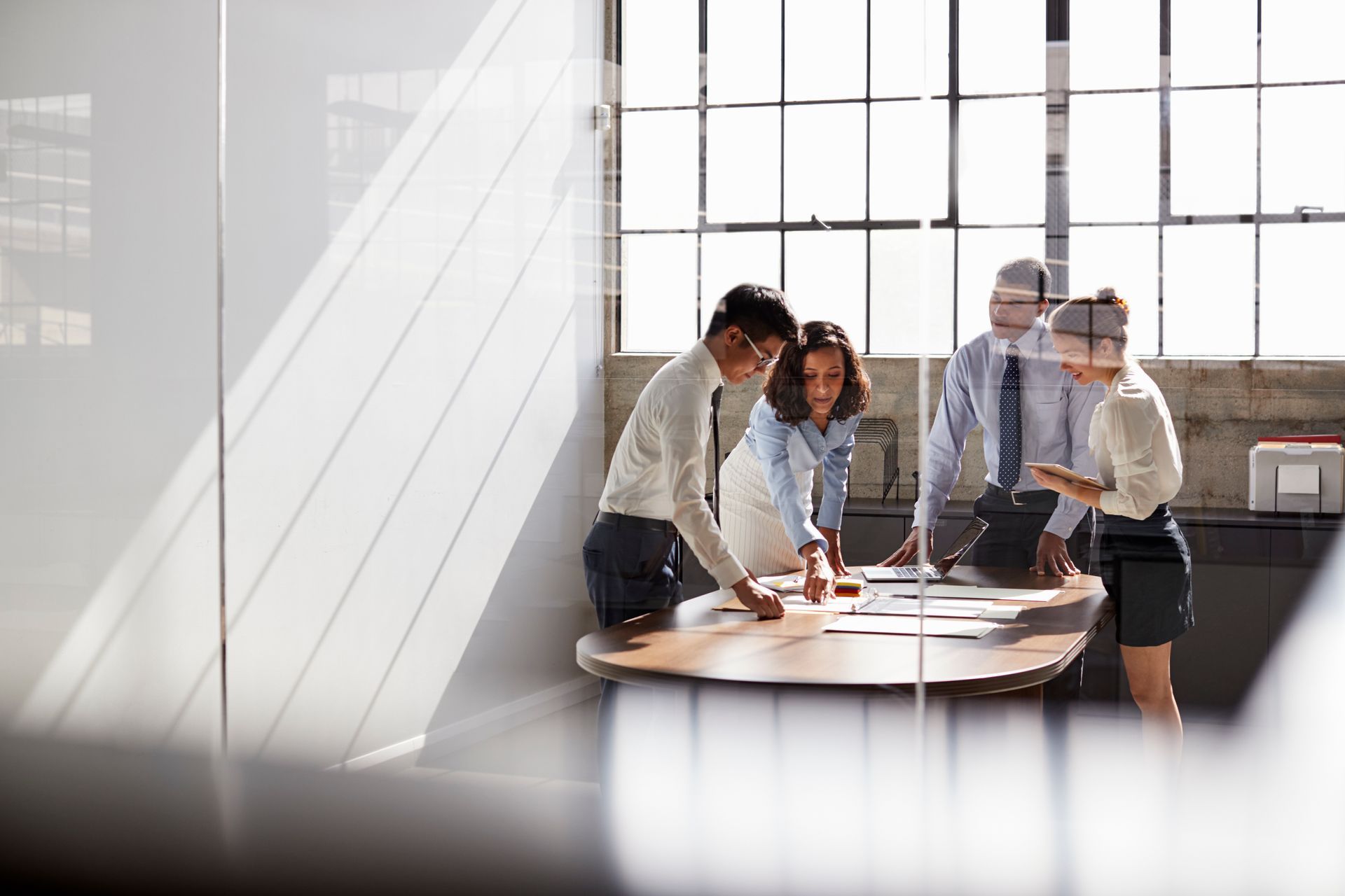 A group of people are sitting around a table in a conference room.
