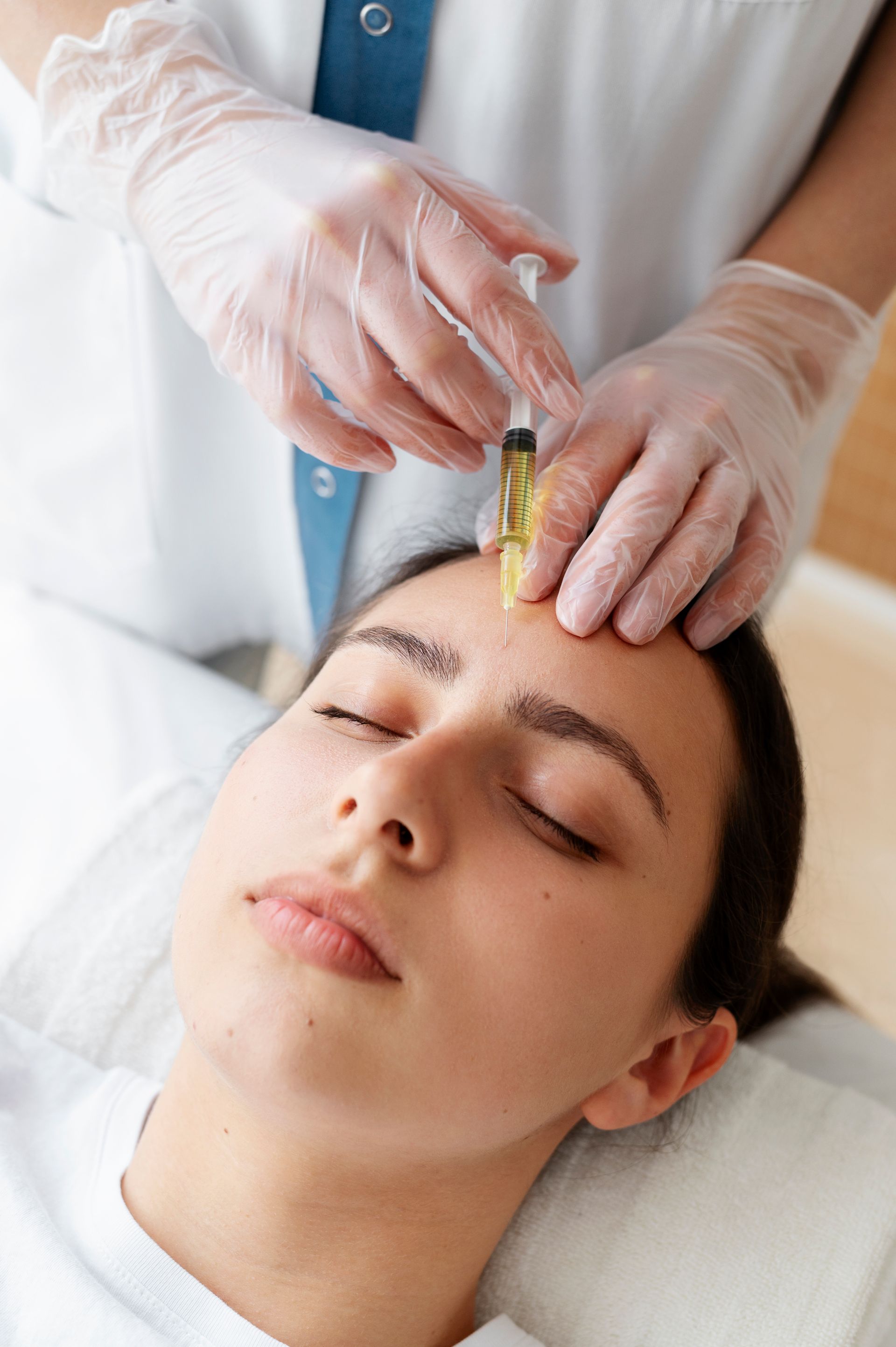 a woman is getting an injection on her forehead