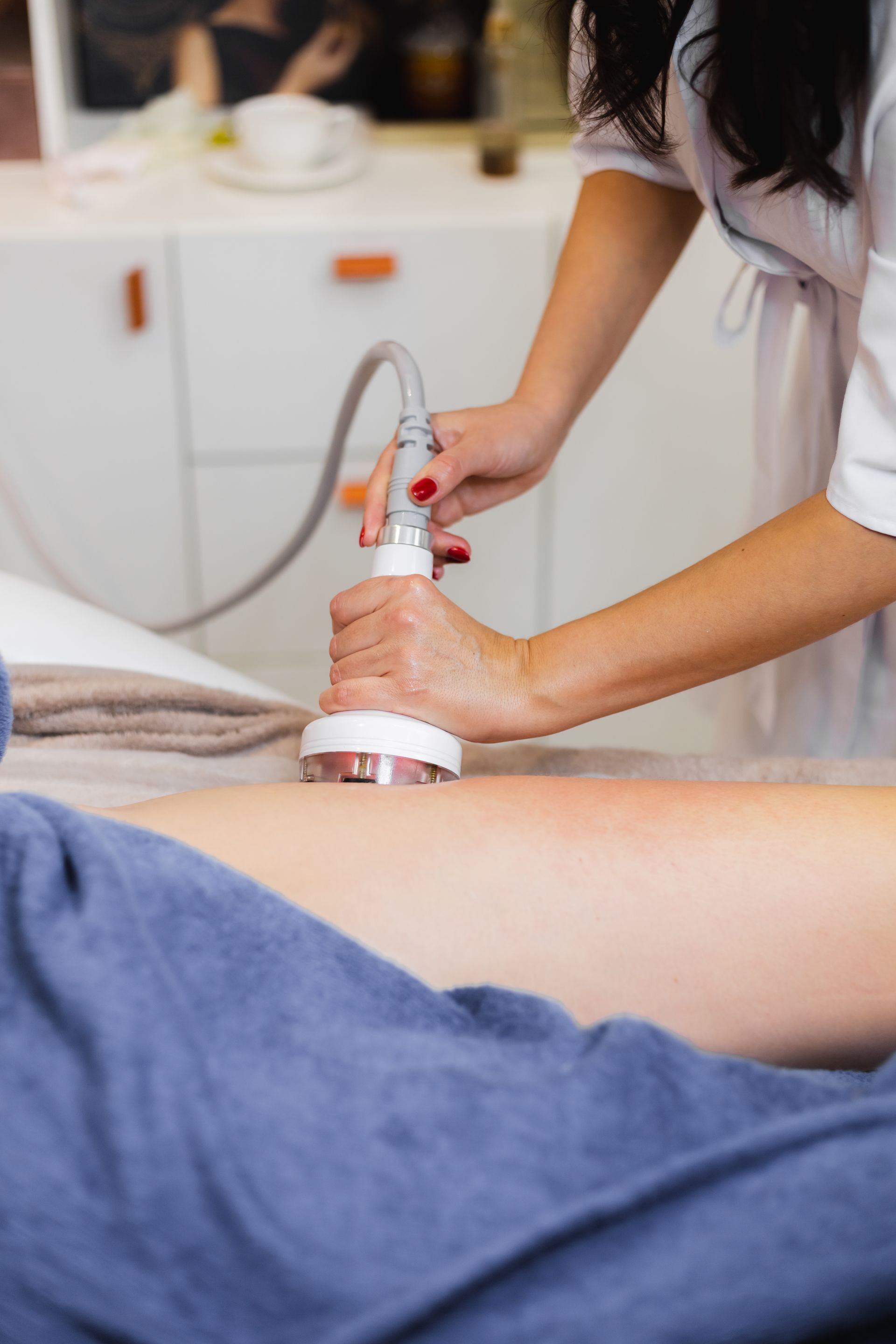 a woman is using a machine on a person 's leg