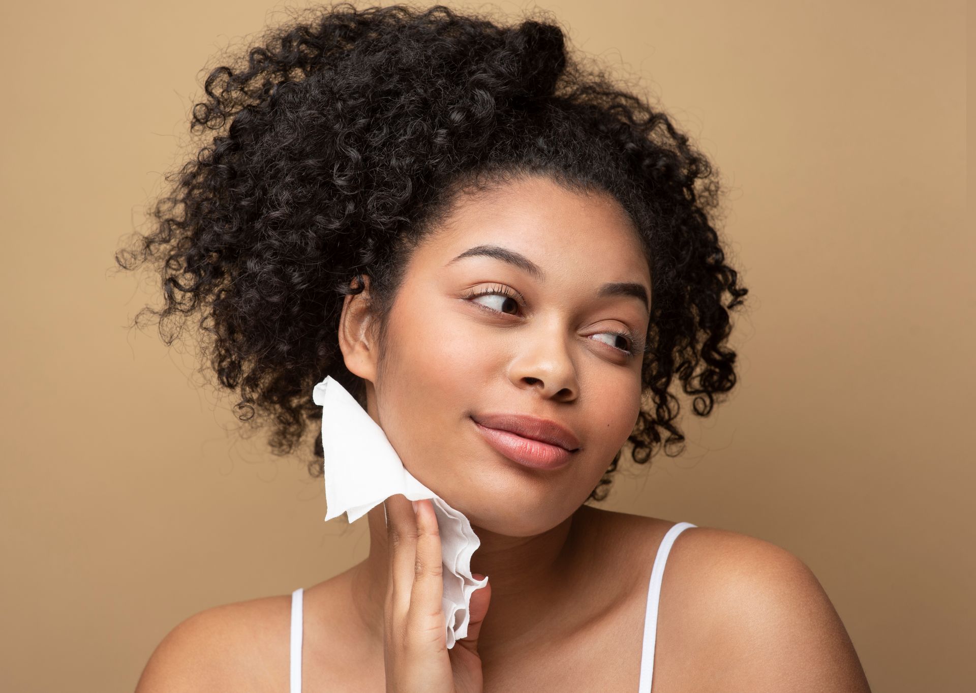 a woman wipes her face with a white cloth