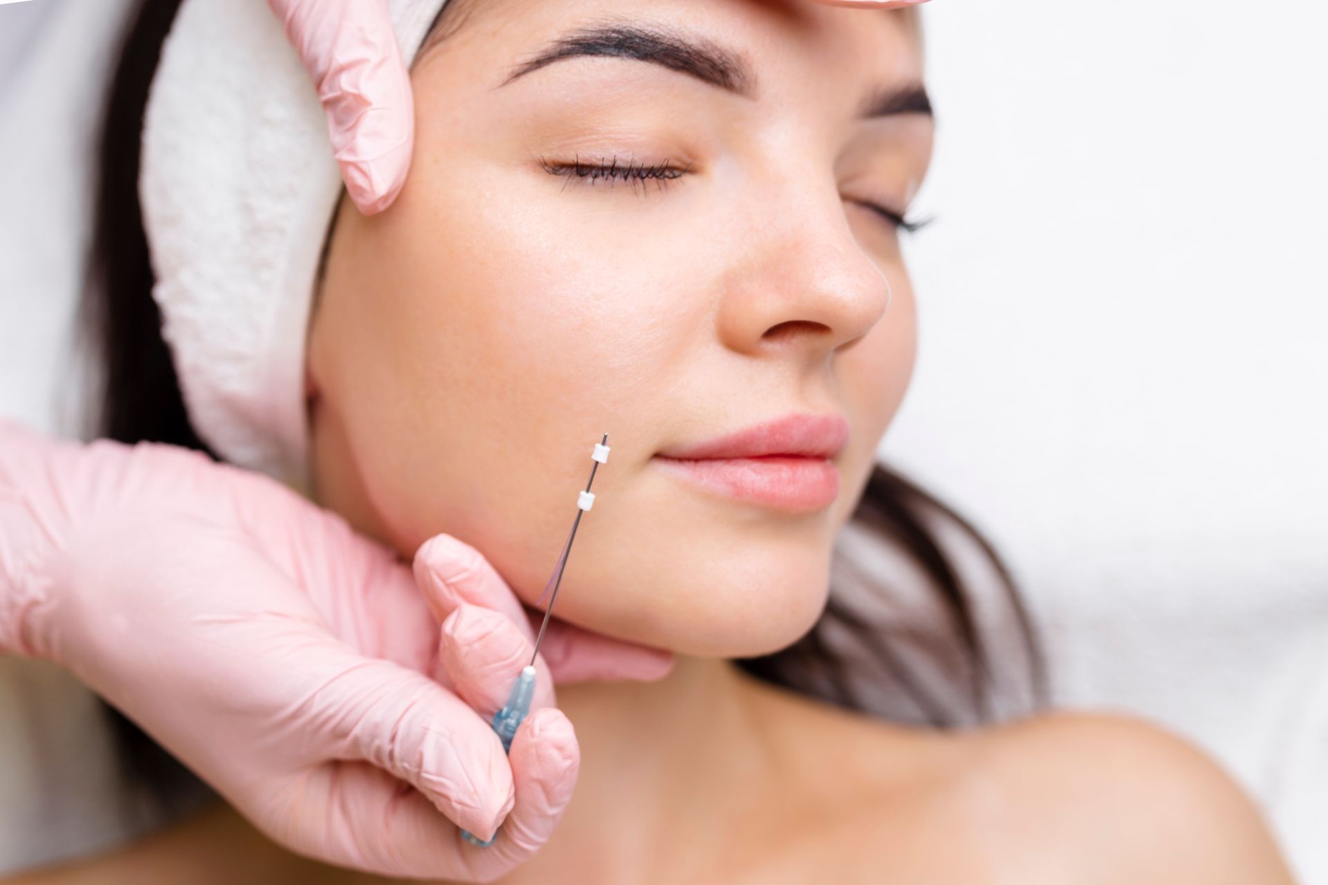 a woman is getting a needle in her face
